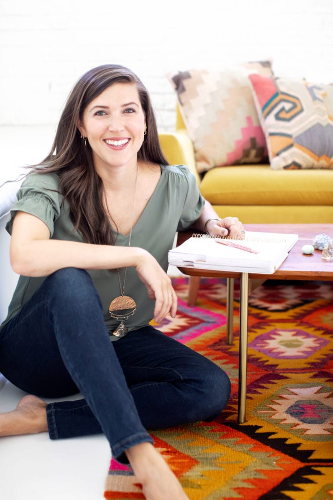 Kate Kordsmeier, blogging expert, sitting next to a coffee table with a notebook