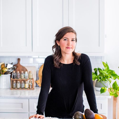 Kate Kordsmeier, a woman wearing black in a white kitchen.
