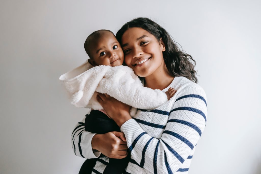 Young mother holding baby and smiling 