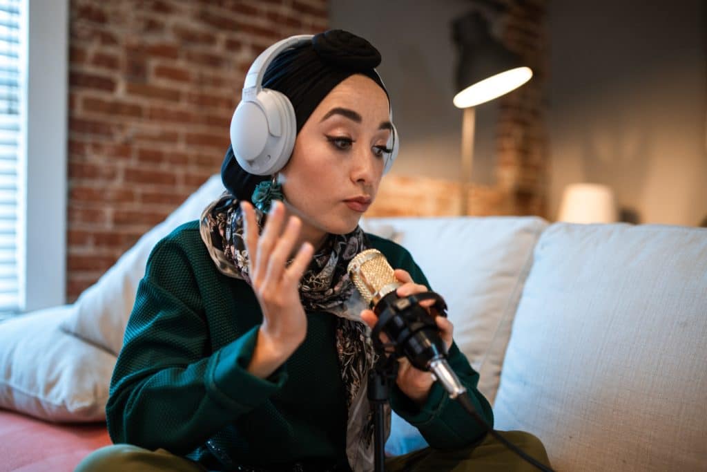 woman wearing headphones and speaking into a camera